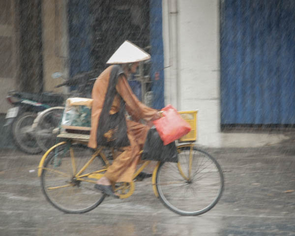Frau auf einem Fahrrad im Regen