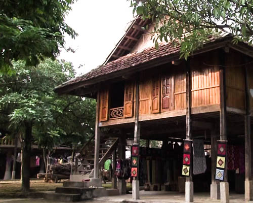 Ein Holzhaus steht auf Stelzen, typisch für eine Thai Volksgruppe