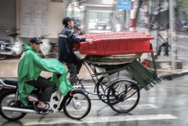Mann auf Lastenfahrrad mit drei Rädern transport viele Stühle