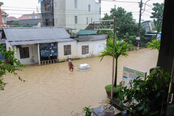 Man im Hochwasser zieht ein schwimmendes Paket